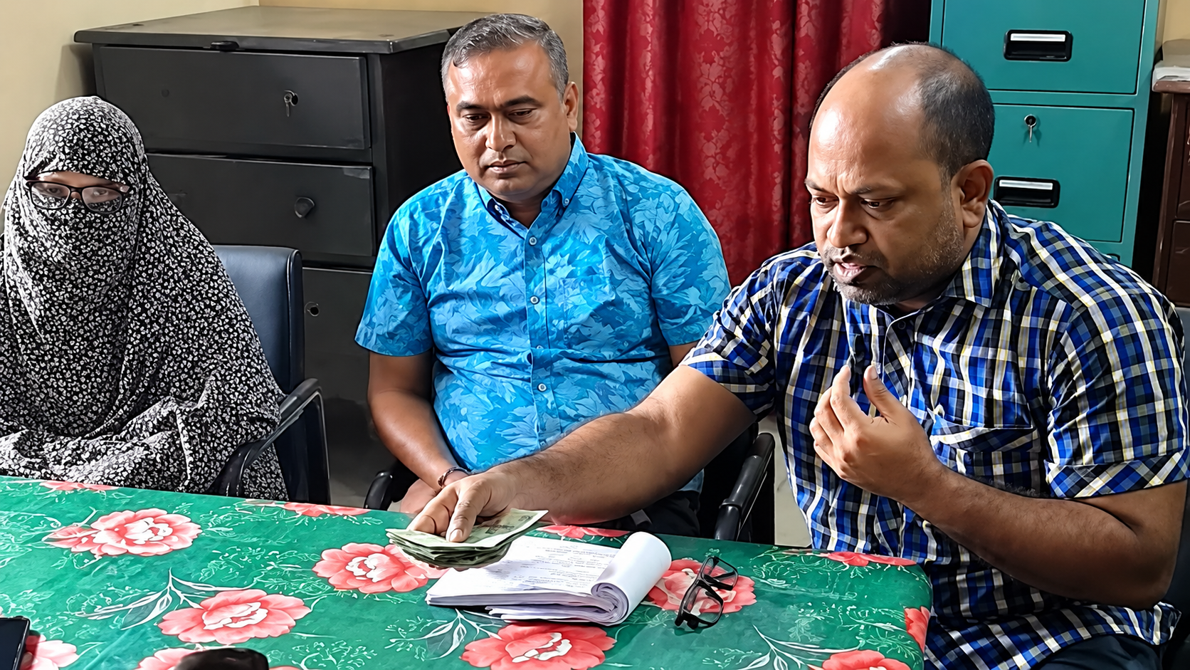 ঈশ্বরদী রেলওয়ে স্টেশনে বিনা টিকিটে ট্রেন ভ্রমণের অর্থ হিসেবে ২৫ হাজার টাকা জমা দিচ্ছেন এক নারী, উপস্থিত রেল কর্মকর্তারা।